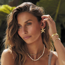 Load image into Gallery viewer, These elegant summer earrings are crafted from stainless steel with a luxurious gold finish, designed in the shape of a starfish to capture the essence of beachside beauty. Perfect for adding a touch of coastal charm, these earrings are an ideal accessory for any outfit, especially during warm summer nights. Featuring a secure and comfortable stud closure, they offer both style and ease of wear.