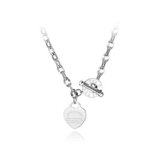 Load image into Gallery viewer, Stainless steel necklace is coming in two colours: rose gold and silver. Big pedant in the shape of a heart is placed at the bottom part. There is a bible proverb engraved on the heart: "Above all else, guard your heart, for everything you do flows from it." Big toggle clasp with engraved letters makes the necklace even more dominant. 