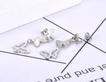Load image into Gallery viewer, Elegant stainless steel earrings are made in a rose gold and silver colour. They consists of three connected butterflies. Butterflies are connected from the smallest one to the biggest. The smallest one has shiny rose gold surface, the middle one is adorned with white shell and the biggest one represents only butterfly silhouette. Earrings are rose gold plated and represent perfect and elegant touch to your evening outfit. They have stud fastening.