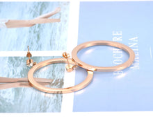 Load image into Gallery viewer, Elegant and classy stainless steel earrings are made in a rose gold colour. Earrings are made of a big circle which hangs on a small cubic zirconia ball. Circles' surface is completely adorned with cubic zirconia. Earrings are rose gold plated and represent perfect and elegant touch to your evening outfit. They have stud fastening.