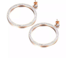 Load image into Gallery viewer, Elegant and classy stainless steel earrings are made in a rose gold colour. Earrings are made of a big circle which hangs on a small cubic zirconia ball. Circles' surface is completely adorned with cubic zirconia. Earrings are rose gold plated and represent perfect and elegant touch to your evening outfit. They have stud fastening.