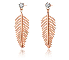 Load image into Gallery viewer, Elegant stainless steel earrings are made in a rose gold colour. They consists of small cubic zirconia on which a leave of fern is hanging. The surface of the fern is sanded which gives the earrings special look. Earrings are rose gold plated and represent great accessory to your elegant outfit. They have stud fastening.