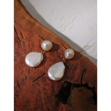 Load image into Gallery viewer, Elegant and luxury earrings are made in a gold colour. They consists of two irregular natural pearls that are hanging one above the other. Lower pearl is bigger than the upper one. Earrings have real gold plating and represent great accessory to your elegant outfit. They have stud fastening.