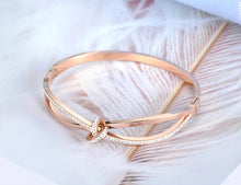 Load image into Gallery viewer, Bangle bracelet is made of stainless steel and comes in two colours: rose gold and silver. It is richly adorned with a bow. The bow has embedded cubic zirconia which makes this bangle perfect accessory for evening night out.