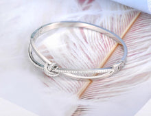 Load image into Gallery viewer, Bangle bracelet is made of stainless steel and comes in two colours: rose gold and silver. It is richly adorned with a bow. The bow has embedded cubic zirconia which makes this bangle perfect accessory for evening night out.