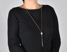 Load image into Gallery viewer, Stainless steel necklace comes in a rose gold colour. It is made of fine thin long chain which is adorned with a beautiful cylinder. Cylinder is additionally decorated with lines of cubic zirconia which makes the necklace perfect accessory for your night out. It has lobster clasp.