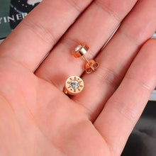 Load image into Gallery viewer, Little round earrings are made of stainless steel in a rose gold colour. They are adorned with cubic zirconia in the middle and engraved "LOVE" letters around it. Earrings are rose gold plated and represent perfect and elegant touch to your day to day style. They have stud fastening.