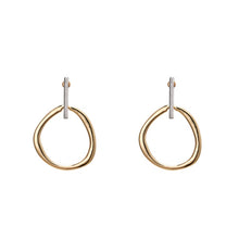 Load image into Gallery viewer, Fashionable and trendy metal earrings are made in a combination of gold and silver colour. They consists of a gold and irregular hollow circle which hangs on a silver stick. Their simplicity gives them very special and glamorous look. Earrings has real gold plating and represent perfect and elegant touch to any outfit. They have stud fastening.