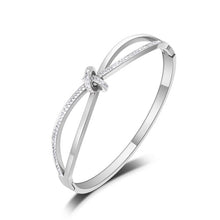 Load image into Gallery viewer, Bangle bracelet is made of stainless steel and comes in two colours: rose gold and silver. It is richly adorned with a bow. The bow has embedded cubic zirconia which makes this bangle perfect accessory for evening night out.