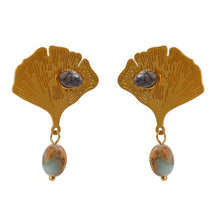 Load image into Gallery viewer, Exquisite stainless steel earrings are made in a gold colour. They are made in a shape of a ginkgo leave which is additionally adorned with natural stone. One smaller stone is placed on the leave and can come in red or green colour. Other bigger stone is hanging under the leave and it has turquoise colour. Earrings have real gold plating and represent great accessory to your everyday outfit. They have stud fastening.