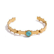 Load image into Gallery viewer, Bangle bracelet is made of stainless steel and it has real gold plating. It comes in gold colour and it is adorned with a beautiful blue stone. Its borders have carvings and interesting structure. It is a perfect accessory for winter or summer outfit.