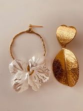 Load image into Gallery viewer, Add a touch of delicate elegance to your look with these minimalistic stud earrings. Featuring thin stainless steel circles adorned with shell flower petals, they offer a perfect blend of modern simplicity and natural beauty. Lightweight and versatile, these earrings are ideal for everyday wear or special occasions, effortlessly complementing any outfit with their subtle charm.
