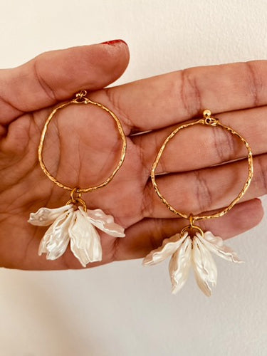 Add a touch of delicate elegance to your look with these minimalistic stud earrings. Featuring thin stainless steel circles adorned with shell flower petals, they offer a perfect blend of modern simplicity and natural beauty. Lightweight and versatile, these earrings are ideal for everyday wear or special occasions, effortlessly complementing any outfit with their subtle charm.