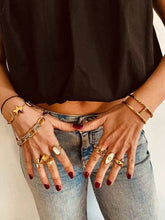 Load image into Gallery viewer, Close-up of hands wearing multiple gold rings and bracelets on a neutral background
