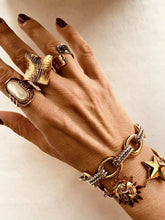 Load image into Gallery viewer, Hand wearing multiple gold rings and a bracelet on a neutral background

