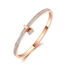 Load image into Gallery viewer, This trendy bracelet features a stunning lock charm adorned with shimmering zircons, set in a rose gold-tone stainless steel bangle for a sophisticated, modern look. The clay pave setting enhances the sparkle of the crystals, adding a luxurious touch to this elegant piece. Perfect as a birthday gift or a stylish addition to any jewelry collection, this bracelet brings a hint of glamour to everyday wear and special occasions alike.
