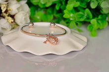 Load image into Gallery viewer, Unlock elegance with this stunning rose gold plated key and lock charm bangle. Beautifully crafted, this bracelet features a delicate key and lock charm adorned with sparkling cubic zirconia stones, adding a touch of glamour to any outfit. The sleek, rose gold finish brings warmth and sophistication, making it a perfect accessory for both casual wear and special occasions. 
