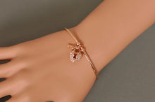 Load image into Gallery viewer, Unlock elegance with this stunning rose gold plated key and lock charm bangle. Beautifully crafted, this bracelet features a delicate key and lock charm adorned with sparkling cubic zirconia stones, adding a touch of glamour to any outfit. The sleek, rose gold finish brings warmth and sophistication, making it a perfect accessory for both casual wear and special occasions. 
