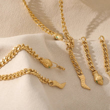 Load image into Gallery viewer, Stainless steel necklace comes in a gold colour. It is made of bigger link chain and it is adorned with a snake head on one side and snake tail on the other side of the necklace. Head is adorned with green cubic zirconia that represent eyes and it serves as a clasp. This luxurious necklace can be worn with any evening outfit and it will make it so glamorous. 
