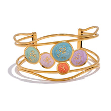 Load image into Gallery viewer, Make a bold statement with our gold-plated stainless steel colorful enamel open angle, designed for fashionable women who love eye-catching accessories. This stylish bangle features an exaggerated, large design adorned with five vibrant enamel circles in red, purple, turquoise, green, and pink, adding a playful splash of color to any outfit. Perfect for making a statement at any occasion, this chic and modern bracelet is a must-have for those who want to stand out with elegance and creativity.
