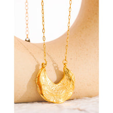 Load image into Gallery viewer, Statement stainless steel necklace comes in a gold colour. It is made of fine thin chain and it is adorned with a nice pendant in the shape of the crescent moon. Interesting shape of the pendant and its irregular surface makes this necklace very glamorous and interesting to be added to any outfit.. It has lobster clasp and adjustable length.
