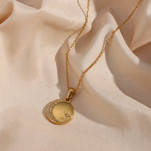 Load image into Gallery viewer, Stainless steel gold plated necklace is made of an elegant and thin chain. There is a round pendant which is adorned with a moon and a star. Both, the moon and the star are made of transparent cubic zirconia. This necklace is a perfect piece for an elegant occasion outfit. It has lobster clasp and adjustable length.
