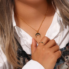 Load image into Gallery viewer, This very elegant pendant necklace is made out of 18K gold plated stainless steel. Pendant is in a shape of a moon and it comes in two colours: black or white. The moon is additionally adorned with a line of cubic zirconia. Necklace can be combined with an elegant dinning outfit and it can be a perfect gift for a special one. It has a size adjustable lobster clasp.&nbsp;
