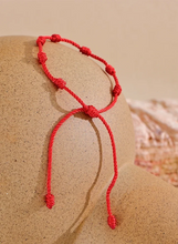 Load image into Gallery viewer, Embrace the power of tradition and style with the adjustable red rope bracelet, expertly handcrafted with braided nodes to symbolize luck, wealth, and good fortune. This meaningful piece is designed for both women and men, making it a thoughtful gift for loved ones or a charming addition to your own collection. The adjustable design ensures a perfect fit for any wrist, while the vibrant red color adds a bold touch to any look. 
