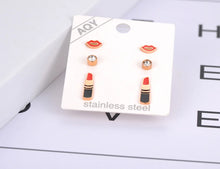 Load image into Gallery viewer, Add a playful touch to your style with this trendy stainless steel lips &amp; lipstick earrings set. Featuring three unique pairs adorned with sparkling cubic zirconia crystals, these earrings are perfect for women who love fun and fashionable jewelry. Lightweight and durable, they effortlessly combine charm and versatility, making them a stylish choice for any occasion or a delightful gift.
