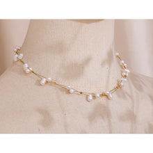 Load image into Gallery viewer, This beautiful handmade necklace, crafted from stainless steel, features a delicate double chain design that exudes elegance and sophistication. The thin chains are adorned with shimmering golden cubes and natural freshwater pearls, creating a striking balance of modern charm and timeless grace. Perfect for glamorous occasions, this necklace adds a touch of refined class to any ensemble.
