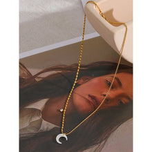 Load image into Gallery viewer, This chic pendant necklace is made out of 18K gold plated stainless steel. It has elegant bead chain and it is adorned with nice white shell moon pendant. Beads are smaller on one side and bigger on the other. The chain is additionally adorned with a small cubic zirconia pendant. This necklace is a perfect piece for an elegant occasion outfit. The necklace has a size adjustable chain with a lobster clasp.&nbsp;
