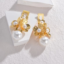 Load image into Gallery viewer, Add a touch of vintage elegance to your look with these stunning statement earrings. Crafted from high-quality stainless steel, they feature three delicate flowers paired with a retro pearls for a timeless and sophisticated charm. Perfect for parties, anniversaries, or any special occasion, these earrings make a beautiful gift for the fashion-forward woman who loves bold yet elegant jewelry.
