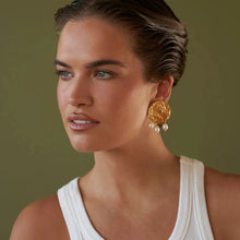 Load image into Gallery viewer, These sophisticated earrings are crafted from stainless steel with a luxurious gold finish. Designed in an elegant circular shape with a hammered texture, they feature three delicate artificial pearls gracefully hanging from each hoop. Perfect for elevating any evening ensemble, these earrings add a touch of timeless charm to special occasions. Secure and comfortable with stud fastenings, they are a versatile addition to your jewelry collection, combining classic style with modern elegance.
