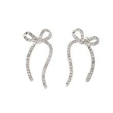 Load image into Gallery viewer, Add a touch of romance and sparkle to your look with these stunning zircon long bowknot dangle earrings. Designed to captivate, each earring features a delicate bow adorned with shimmering zircon stones, creating an elegant and eye-catching effect. Crafted from high-quality stainless steel, these earrings are available in both gold and silver, offering versatile options to match any outfit. 
