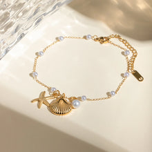 Load image into Gallery viewer, This exquisite gold-tone stainless steel anklet is the ultimate summer accessory, designed to elevate any warm-weather look. The delicate chain is adorned with flawless pearl imitations and three charming pendants—a starfish, a seashell, and a pearl—evoking the beauty of the sea and adding a touch of coastal elegance. With its secure lobster clasp and adjustable chain, this anklet offers a comfortable, customizable fit.
