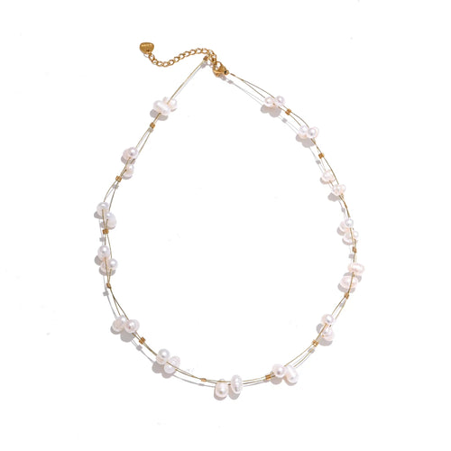 This beautiful handmade necklace, crafted from stainless steel, features a delicate double chain design that exudes elegance and sophistication. The thin chains are adorned with shimmering golden cubes and natural freshwater pearls, creating a striking balance of modern charm and timeless grace. Perfect for glamorous occasions, this necklace adds a touch of refined class to any ensemble.