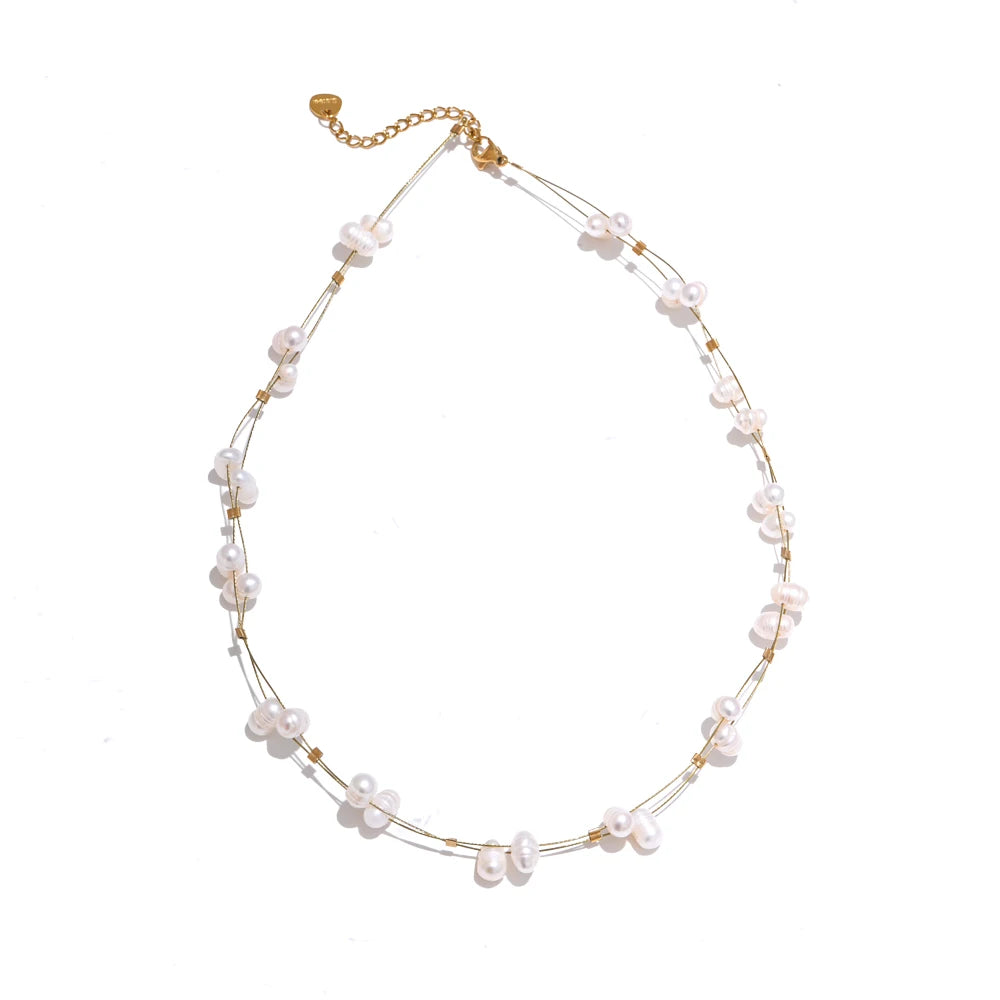 This beautiful handmade necklace, crafted from stainless steel, features a delicate double chain design that exudes elegance and sophistication. The thin chains are adorned with shimmering golden cubes and natural freshwater pearls, creating a striking balance of modern charm and timeless grace. Perfect for glamorous occasions, this necklace adds a touch of refined class to any ensemble.