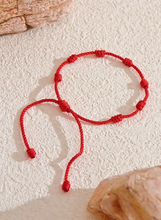 Load image into Gallery viewer, Embrace the power of tradition and style with the adjustable red rope bracelet, expertly handcrafted with braided nodes to symbolize luck, wealth, and good fortune. This meaningful piece is designed for both women and men, making it a thoughtful gift for loved ones or a charming addition to your own collection. The adjustable design ensures a perfect fit for any wrist, while the vibrant red color adds a bold touch to any look. 
