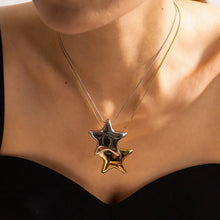 Load image into Gallery viewer, This statement stainless steel necklace comes in a gold and silver colour. It is adorned with a big bulging star pendant that is in contrast with a fine thin chain. This contrast makes it a perfect accessory for any rock glam outfit. The necklace has lobster clasp and adjustable chain.
