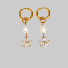 Load image into Gallery viewer, Elevate your style with these pearl flower zircon tassel earrings, designed to add graceful charm to any outfit. Crafted from durable stainless steel with a luxurious PVD gold-plated finish, they feature a delicate pearl flower accented with sparkling zircon stones and elegant tassel details. Fashionable yet timeless, these earrings are lightweight, comfortable to wear, and make a perfect gift for women who love refined, eye-catching jewelry.
