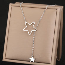 Load image into Gallery viewer, This elegant stainless steel necklace comes in two colours: silver and gold. It is adorned with two star pendants which are positioned at both ends of the chain. Smaller full star pendant needs to be pulled through the star silhouette, which is also the way the necklace should be worn. It is a perfect piece for a daily outfit but can surely spice up evening combination as well. The necklace has lobster clasp.
