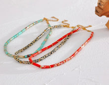 Load image into Gallery viewer, Necklace is made out of big red natural stone beads in a shape of a cilindar. There are small beads in between the red ones made of stainless steel in gold colour. This necklace is a perfect piece for summer elegant outfit. The necklace has a size adjustable chain with a lobster clasp.&nbsp;
