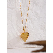 Load image into Gallery viewer, This romantic 18K gold plated stainless steel necklace comes in a gold colour. It is adorned with a beautiful carved heart pendant. The heart medallion can be opened and it can be used for photo saving. Heart necklace is perfect for spicing up your romantic outfit and it is also very suitable gift for your loved ones. It has lobster clasp and adjustable length.
