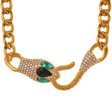 Load image into Gallery viewer, This beautiful statement stainless steel necklace comes in a gold colour. It is made of big link chain and it is adorned with a snake head and tail that is also a clasp. Both, head and tail, are adorned with beautiful cubic zirconia. This luxurious necklace can be worn with any evening outfit and it will make it so glamorous. 
