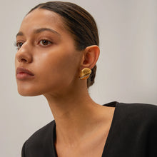 Load image into Gallery viewer, Add a touch of elegance and sparkle to your style with these 18K gold plated stainless steel cross line inlaid rhinestone stud earrings. Featuring a sleek cross-line design adorned with shimmering rhinestones, these earrings are perfect for adding a sophisticated finish to any look. Crafted from durable stainless steel with a radiant gold plating, they offer long-lasting shine and tarnish resistance. 
