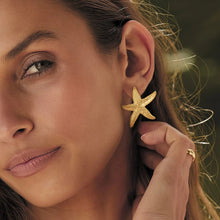 Load image into Gallery viewer, These elegant summer earrings are crafted from stainless steel with a luxurious gold finish, designed in the shape of a starfish to capture the essence of beachside beauty. Perfect for adding a touch of coastal charm, these earrings are an ideal accessory for any outfit, especially during warm summer nights. Featuring a secure and comfortable stud closure, they offer both style and ease of wear.
