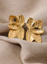 Load image into Gallery viewer, These bold flower stud earrings, crafted from waterproof stainless steel in a radiant gold color, feature large, eye-catching petals that make a high-quality fashion statement. Their oversized floral design offers a touch of elegance and femininity, perfect for adding flair to any outfit. Durable and beautifully crafted, these earrings are ideal for women who appreciate stylish, standout accessories. 
