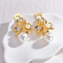 Load image into Gallery viewer, Add a touch of vintage elegance to your look with these stunning statement earrings. Crafted from high-quality stainless steel, they feature three delicate flowers paired with a retro pearls for a timeless and sophisticated charm. Perfect for parties, anniversaries, or any special occasion, these earrings make a beautiful gift for the fashion-forward woman who loves bold yet elegant jewelry.
