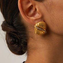 Load image into Gallery viewer, Add a touch of elegance and sparkle to your style with these 18K gold plated stainless steel cross line inlaid rhinestone stud earrings. Featuring a sleek cross-line design adorned with shimmering rhinestones, these earrings are perfect for adding a sophisticated finish to any look. Crafted from durable stainless steel with a radiant gold plating, they offer long-lasting shine and tarnish resistance. 
