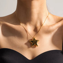 Load image into Gallery viewer, This statement stainless steel necklace comes in a gold and silver colour. It is adorned with a big bulging star pendant that is in contrast with a fine thin chain. This contrast makes it a perfect accessory for any rock glam outfit. The necklace has lobster clasp and adjustable chain.
